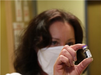 Mgr. Olga Mučicová, hlavní farmaceut Krajské zdravotní, a.s., ukazuje vícedávkovou injekční lahvičku s vakcínou proti nákaze novým koronavirem SARS-CoV-2 od společnosti Pfizer/BioNTech. Foto: Krajská zdravotní, a.s.